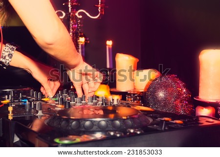DJ hands on the remote. nightclub