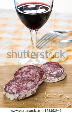 sliced Ã?Â¢??Ã?Â¢??salami and glass of wine on the table