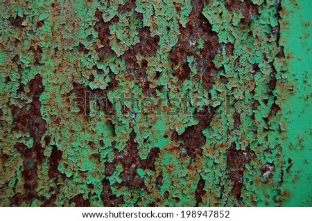 Old cracked paint pattern on rusty background. Peeling paint. Pattern of rustic green grunge material. Damaged paint on the metal surface. Scratched old metal plate