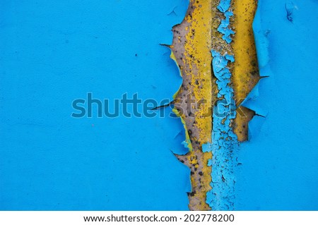 Old cracked paint pattern on concrete background. Peeling paint. Pattern of blue and yellow grunge material. Damaged paint. Scratched old plate