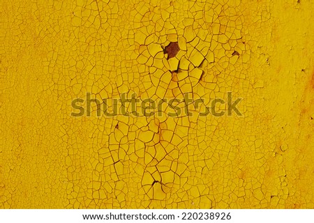 Yellow cracked paint on metal rusty surface