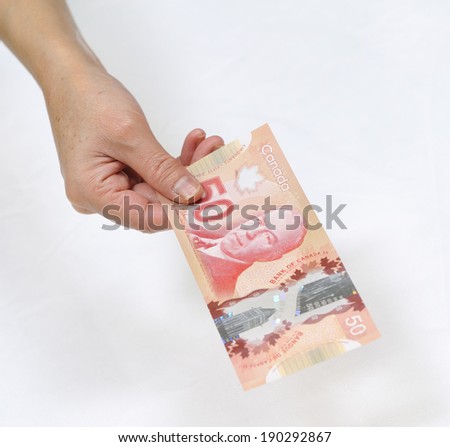 MONTREAL - NOVEMBER 19: A hand is holding a Canadian fifty dollar bill is photographed on November 19, 2012 in Montreal, Quebec, Canada.