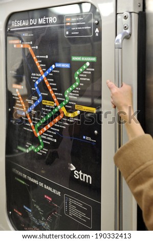 MONTREAL - APRIL 26: A hand grips a subway pole in a car right beside the Montreal Metro system map, on April 26, 2014 in Montreal, Quebec, Canada.