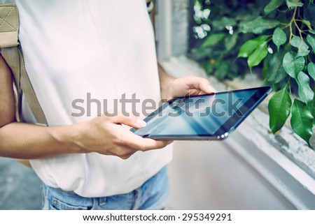 Woman using digital tablet. girl with a backpack holding a tablet