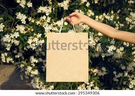 woman holding a bag on a background of flowers