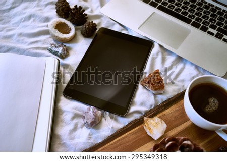 Tablet on background composition of the laptop, tea, minerals, notebook and cones. modern devices