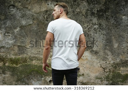 blank white t-shirt on muscle young man, dark concrete background