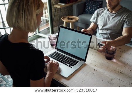 Creative female freelancer sitting front laptop computer with blank copy space screen for your information. young man and young woman working opposite each other with laptops