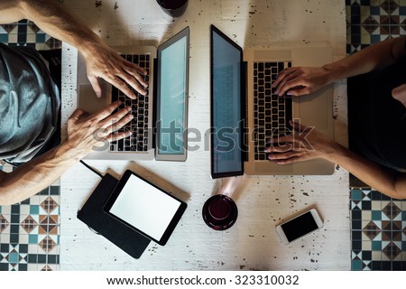 top view of a young woman and a young man who works with a laptops. phone and tablet on the table.  digital tablet with blank copy space screen for your information