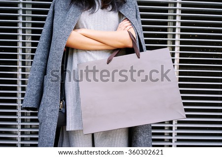 Close up female hands holding a blank paper bag with empty space for your text or logo