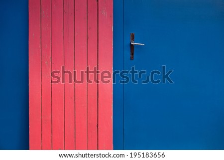 blue metal door handle with a red wooden plate