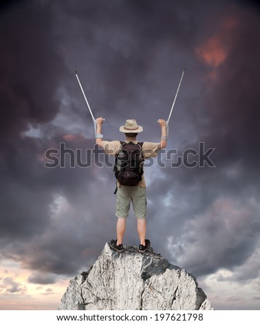 disabled man with crutches on top of the rock