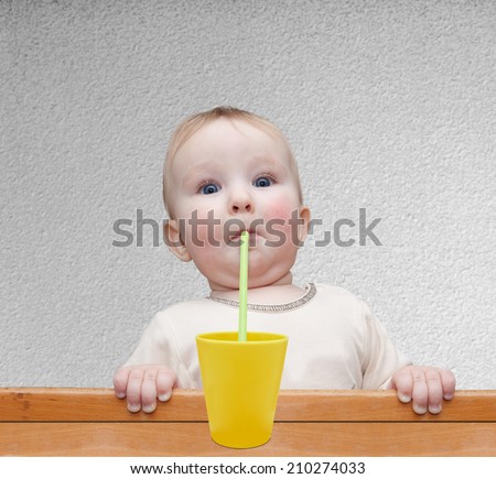 little boy drinking through a straw yellow lemonade