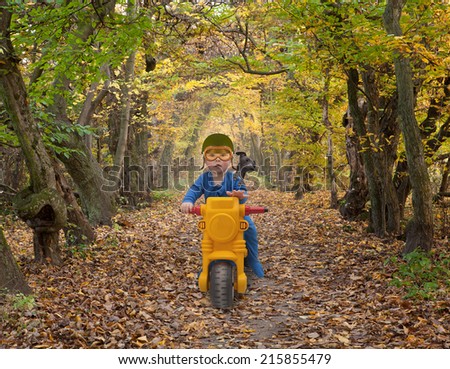 little boy with a dog on a children\'s bike in the park
