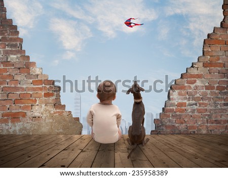baby and dog watching the kite from the ancient ruins