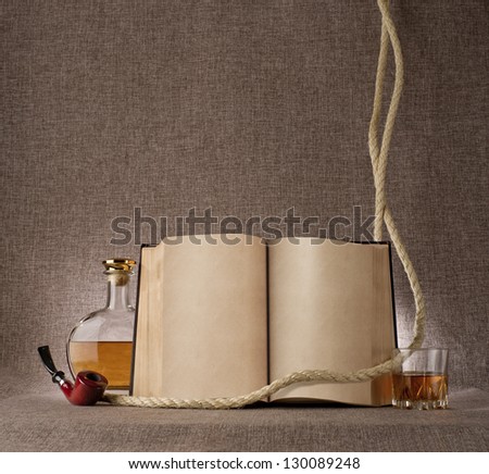 vintage still life with book, whiskey and tobacco pipe on the background fabric texture