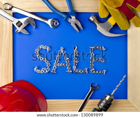 tools and helmet on a blue background in a wooden frame with the inscription sale