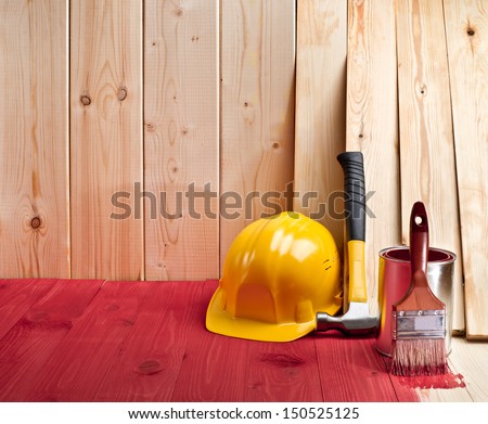 wood floor and wall with a brush, paint, hammer and yellow helmet