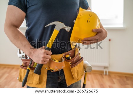 construction worker with tool belt, helmet and hammer