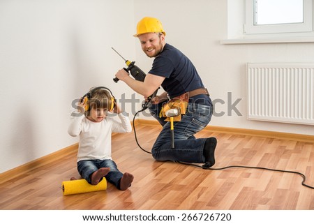 construction worker in helmet with a drill and a little child make repairs in the house