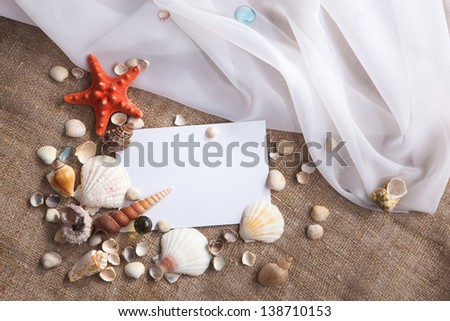 Memories of holidays by the sea. Background with blank card and shells.