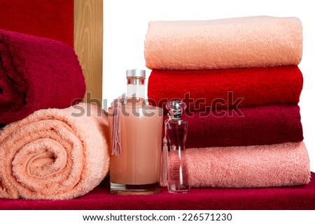 a neat stack of terry towels on a rack isolated on white background
