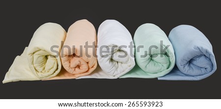 row of colorful twisted blankets isolated on black background