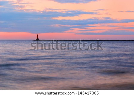 Rattray head lighthouse on the north east coast of Scotland as the Sun setting with the tide coming in