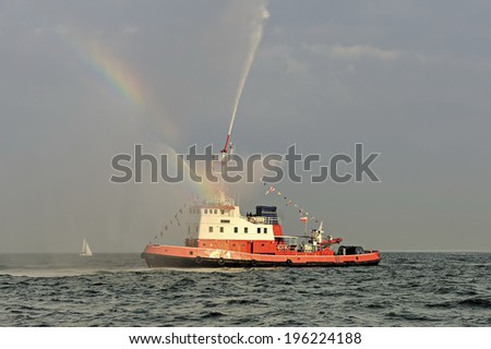 A fireboat casting water stream at open water