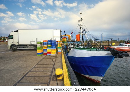 Fishing Boats in a Harbour,loading fish on refrigerated vehicles