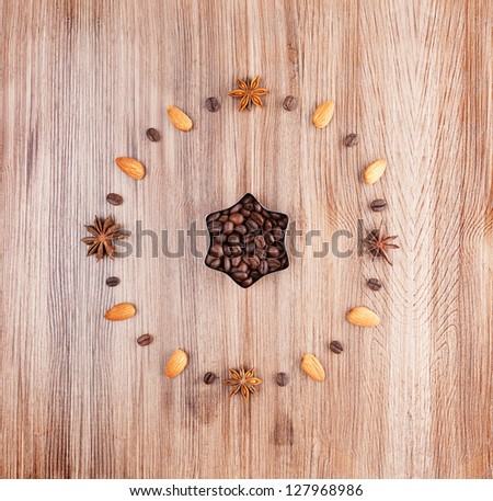 Coffee time. Clock face on a wooden background of almonds and coffee beans