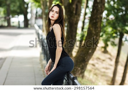 Beautiful fashionable woman in the morning light and in the park