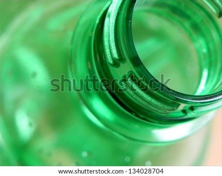Fresh opened green bottle of mineral water macro view./Opened mineral water