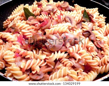 Home cooked pasta Fussili with mushrooms and tomato spiced with laurel basil and white wine./Pasta with mushrooms and tomato
