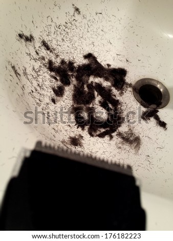 Close view on hair in the sink after being cut of with hair trimmer/Trimmer hair cut