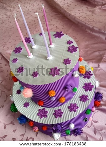 Velvet cardboard cake with nice flower decoration and four candles on the top with velvet background/Cardboard cake