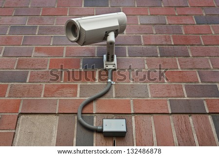 cctv security video camera  on outside wall of a building