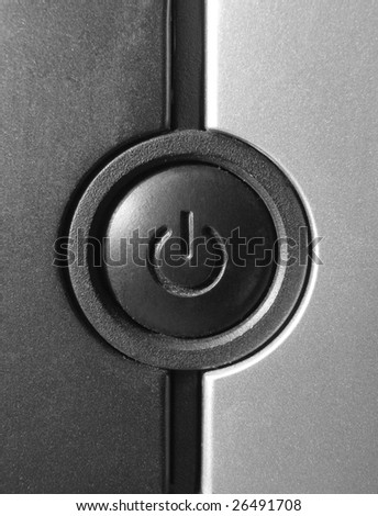 Black power button closeup on a back/grey PC