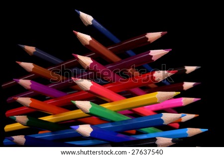 Bottom view of colored pencils tower isolated over black background