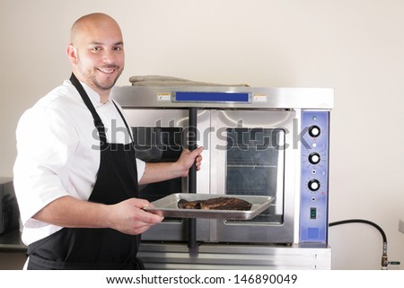 Happy chef taking his freshly baked rib-eye steak