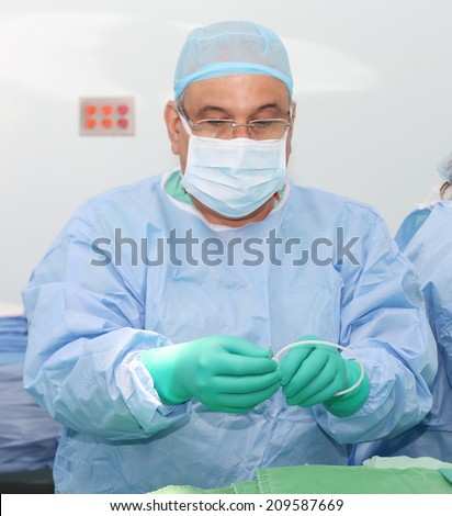 Doctor preparing a catheter for insertion on a patient. Slide Safe-T-J wire guide straightener.  Focus in the hand.