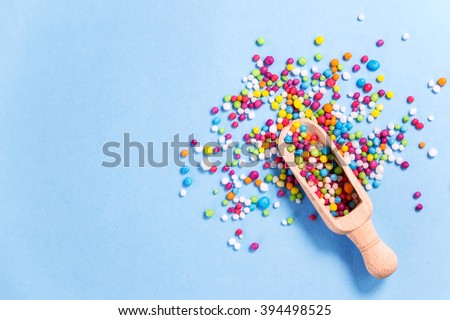 Wood scoop with colored candy on,colorful eatable sugar pearls.Useful for food background