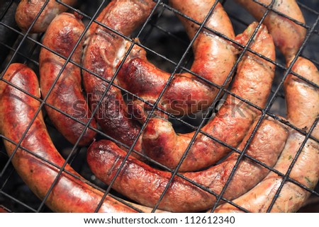 Closeup of sausages cooking on the grill. Good background