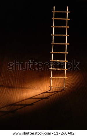 Escape abstract. Wooden ladder with shadow on dark background