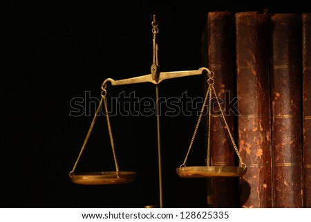 Closeup of old brass weight scale on books background