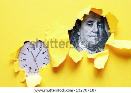 Time Is Money. Clock and one hundred dollar bank note inside holes in yellow paper sheet