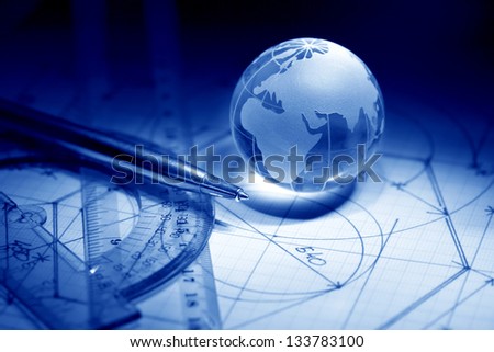 Business concept. Glass globe near rulers on graph paper surface with draft