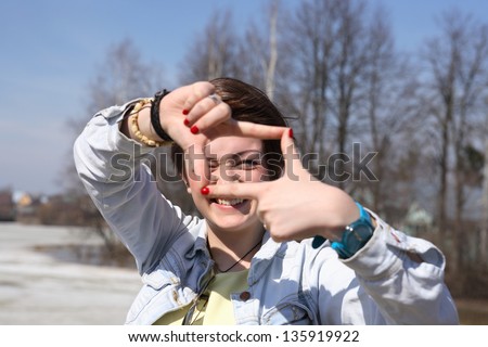 Young Photographer. Portrait of beautiful young girl make picture frame with her fingers