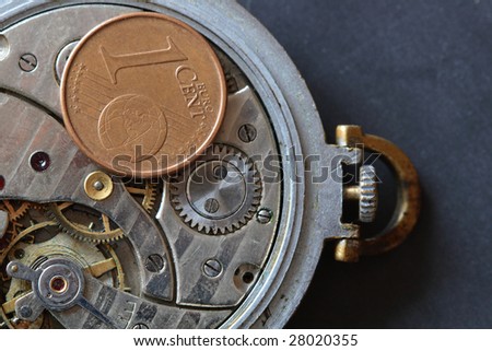 European one cent coin lying on watch mechanism