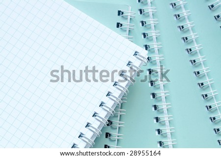Close-up of few closed and one opened spiral notebooks